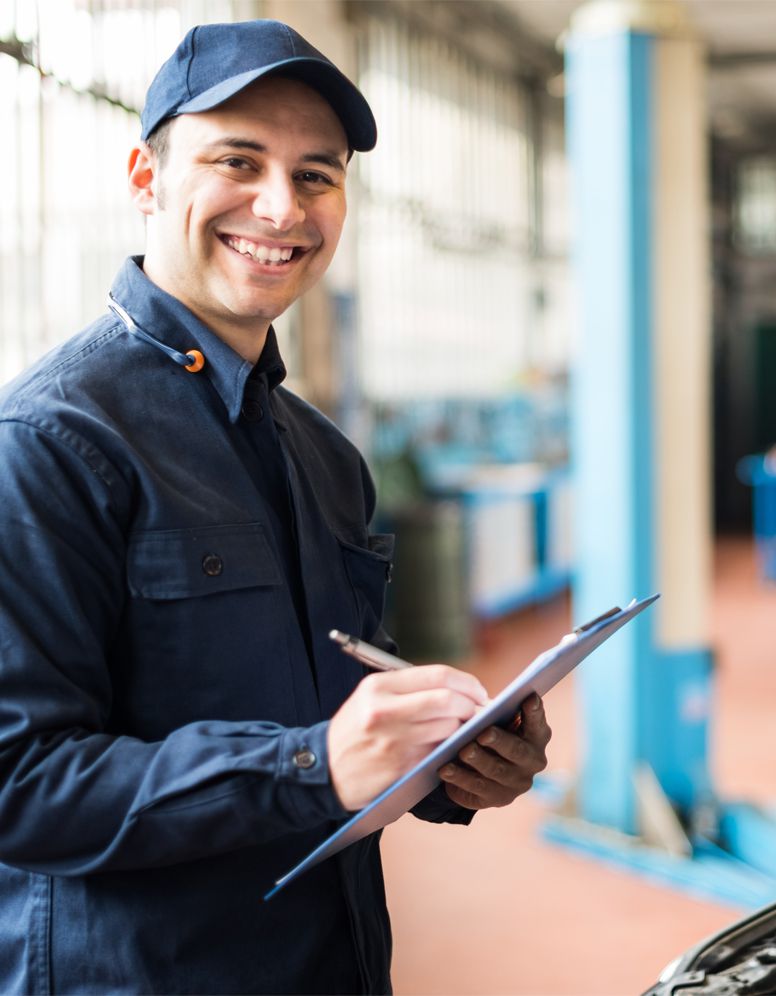 Happy technician ticking off a service sheet - MOT and Servicing Sutton Coldfield