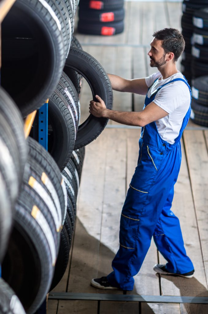 Mechanic pulling out a tyre from stock - Tyres Sutton Coldfield